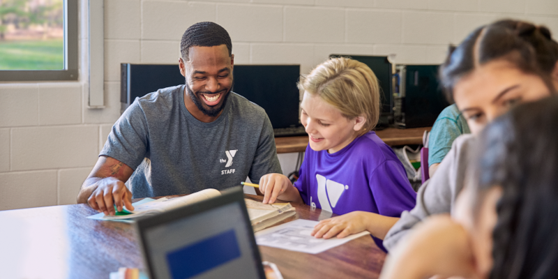 Photo of YMCA Staff doing homework with a YMCA youth member