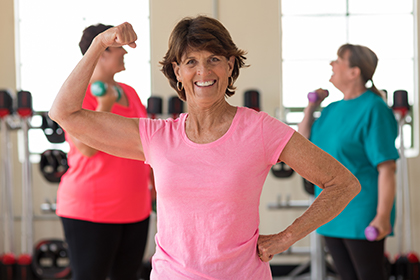 Photo of a woman flexing her bicep at the gym