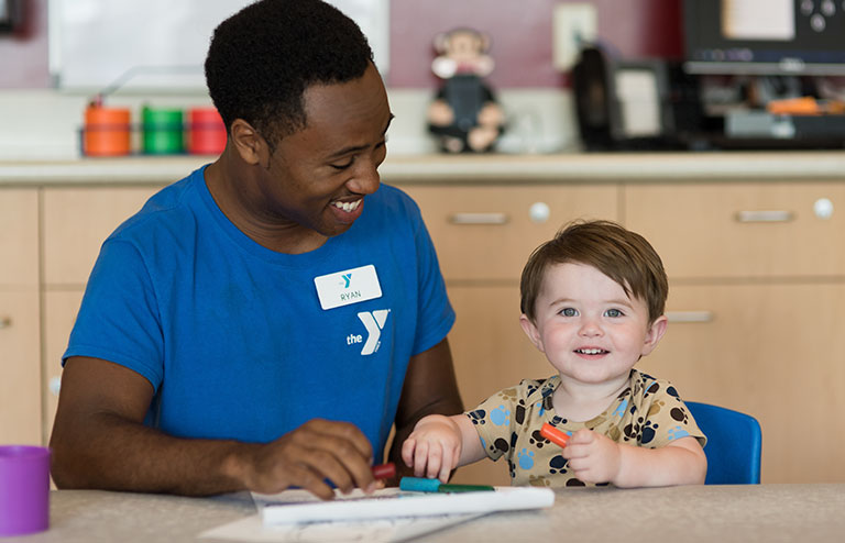 Photo of a man with a child at a child care center