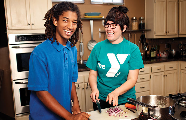 Photo of two members of the YMCA preparing food together