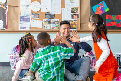 smiling kids high five teacher