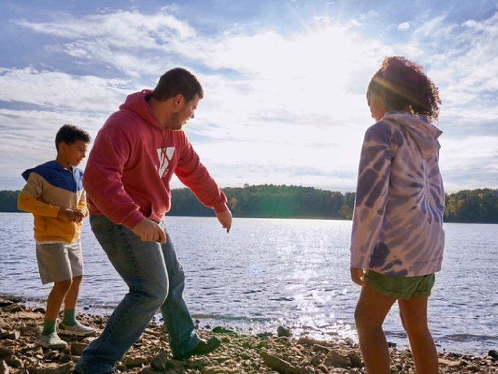 Photo of YMCA members skipping rocks at a lake