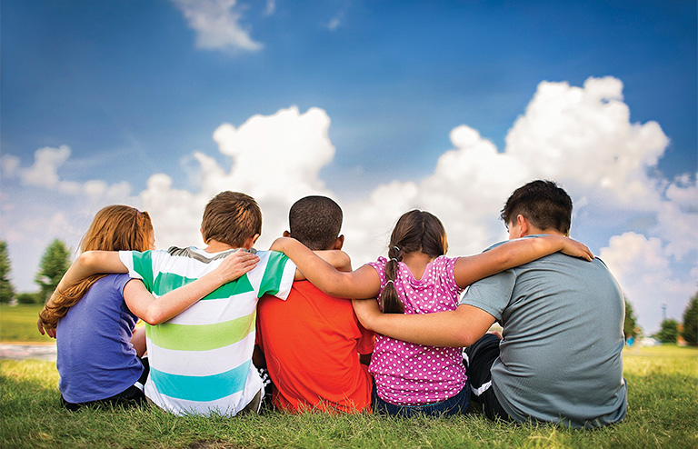 Photo of YMCA kids holding each other over the shoulders