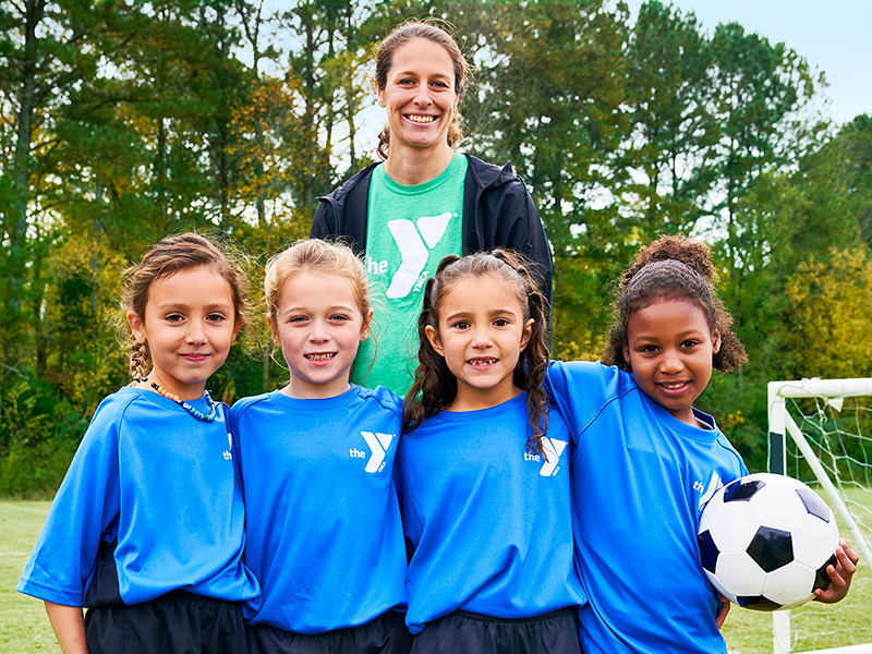 Photo of a YMCA Soccer coach with her four youth soccer players