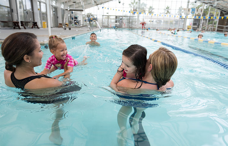 Photo of two swim instructors with young swimmers