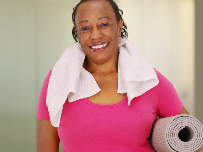 Photo of a YMCA member holding a yoga mat