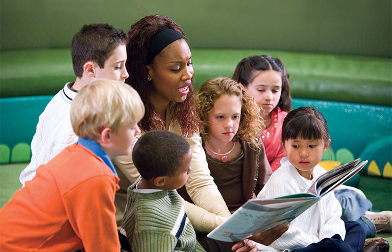 Photo of a child care provider with six children