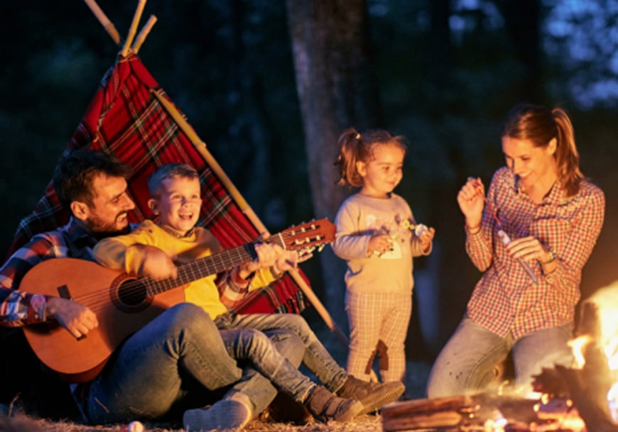 family around a camp fire at overnight camp
