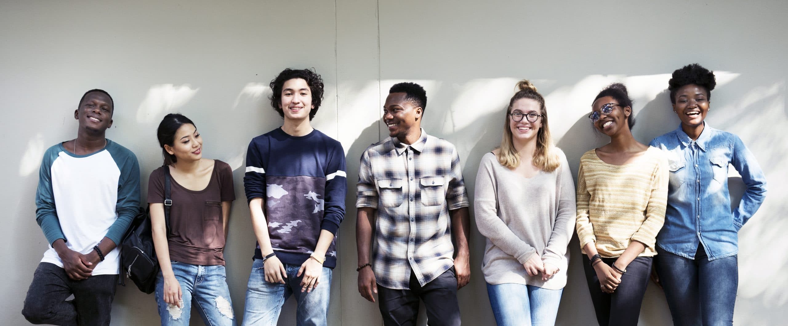 Young Adults Standing Together Against Wall
