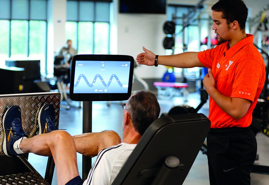 member and coach using EGYM exercise equipment