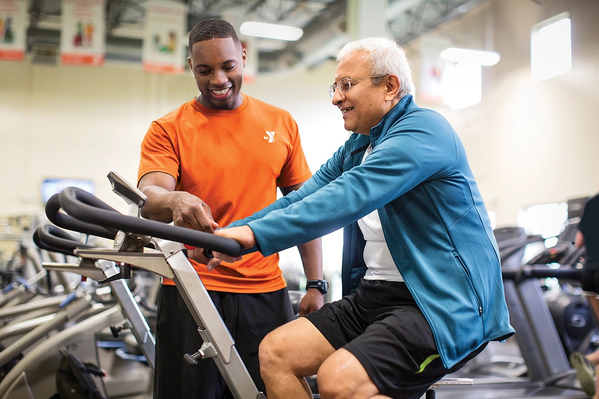 staff person showing member how to use exercise machine