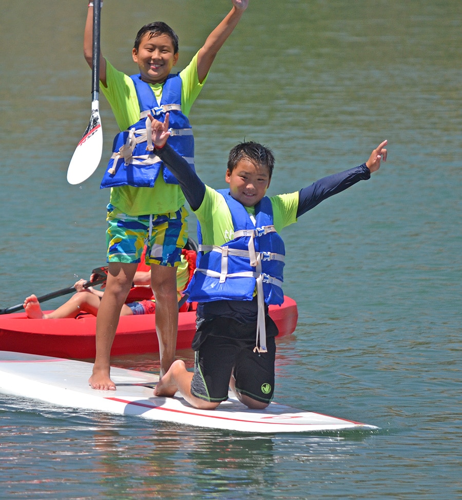 kids playing on paddleboard at camp